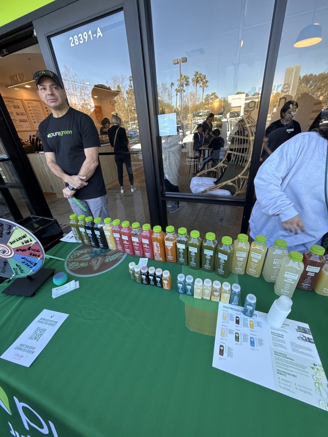 Pure Green Mission Viejo staff at a cold-pressed juice sampling table