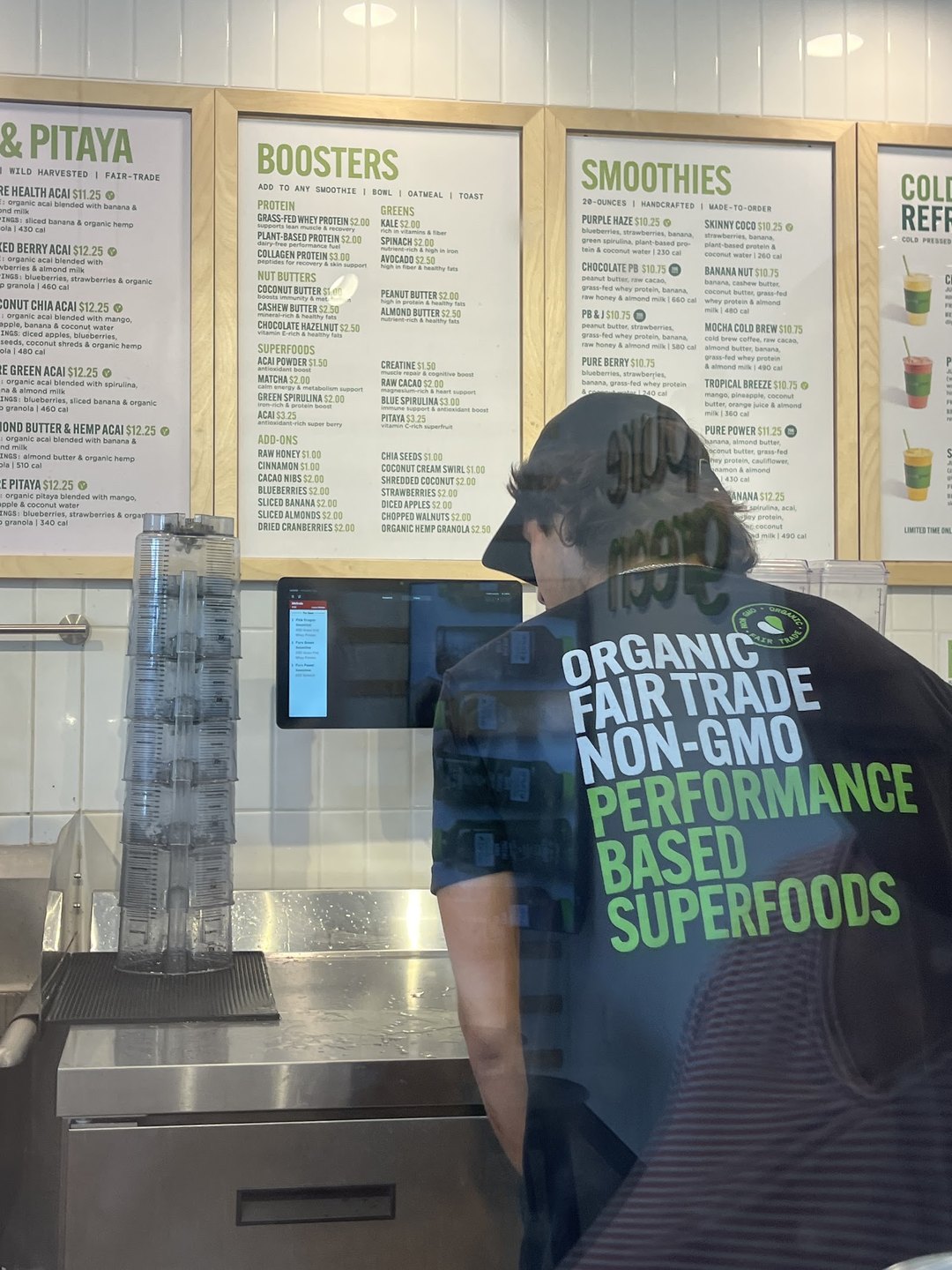 Team member preparing orders under the menu boards at Pure Green Mission Viejo