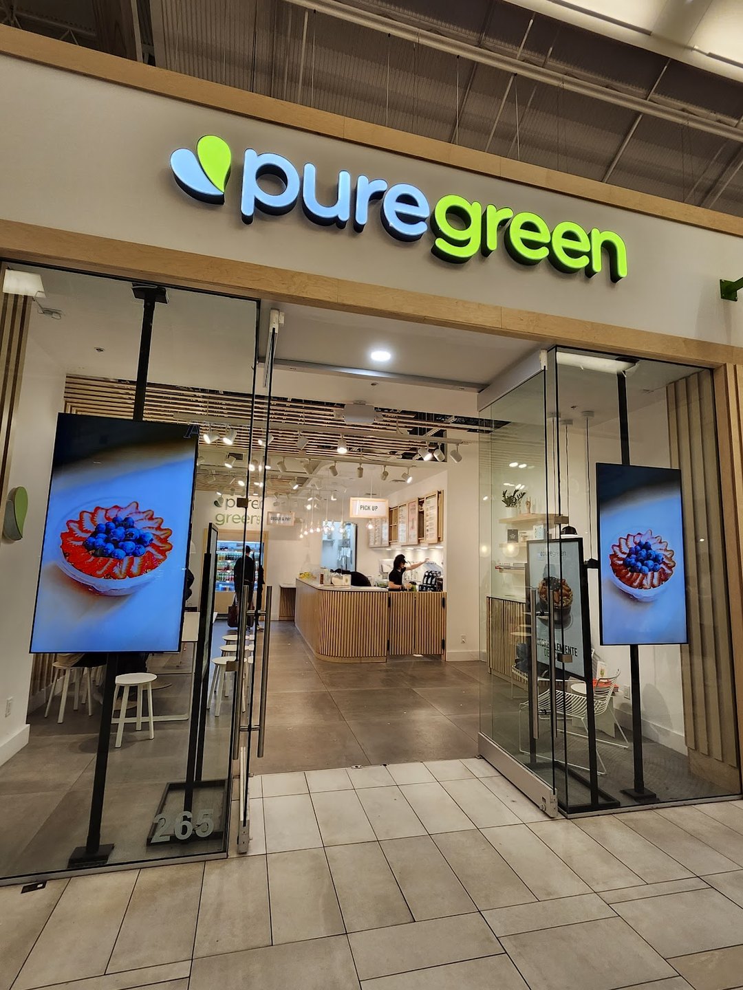 Pure Green Sawgrass Mills storefront with digital menu screens at the mall