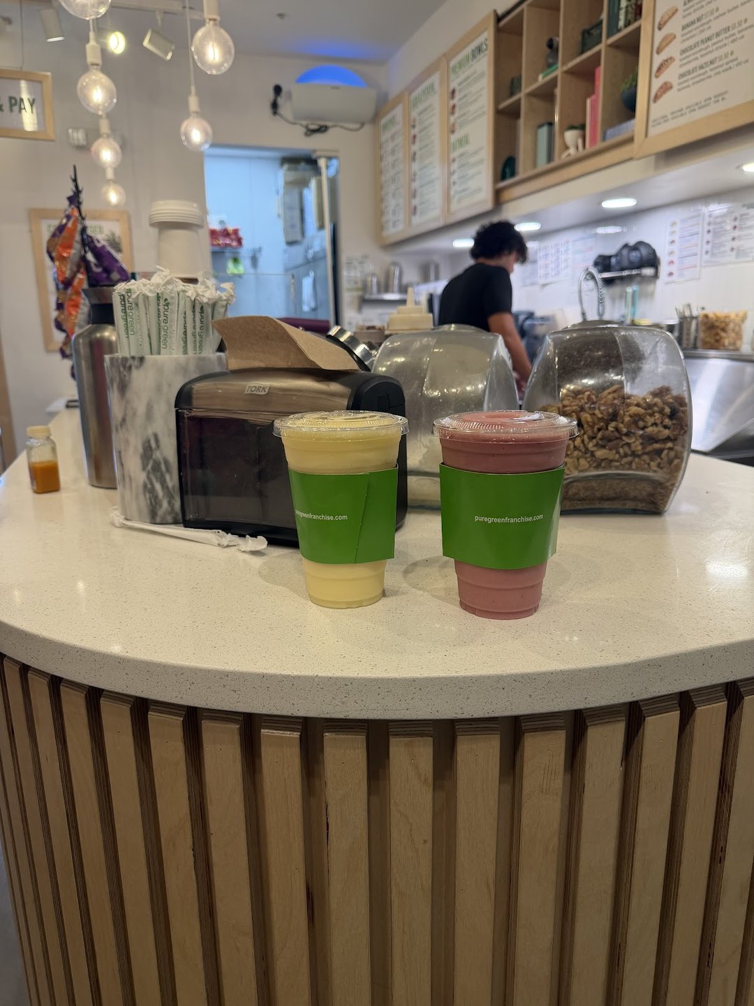 Smoothies on the counter with a team member at Pure Green Sawgrass Mills