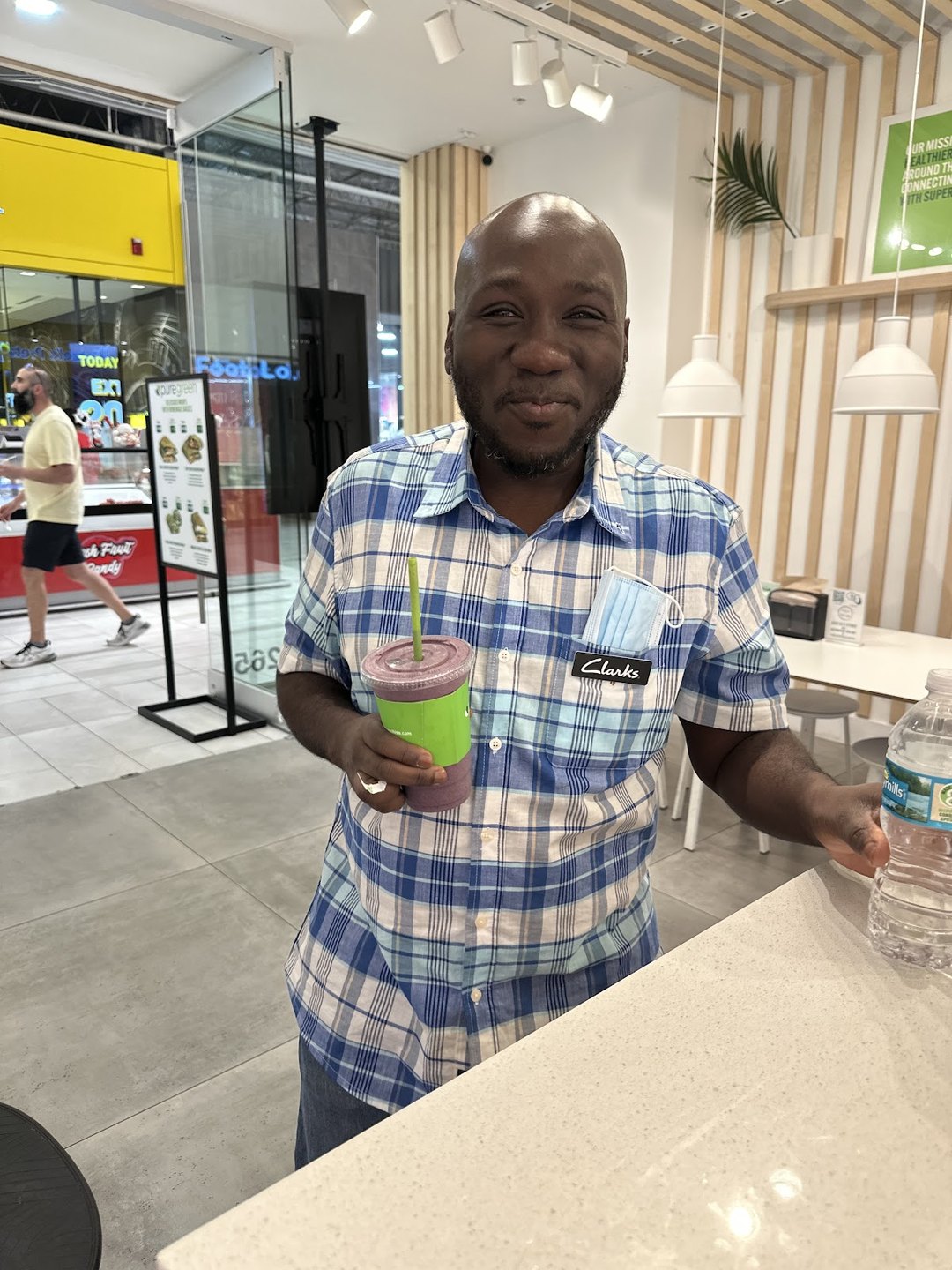Guest holding a fresh green smoothie at the Pure Green Sawgrass Mills counter
