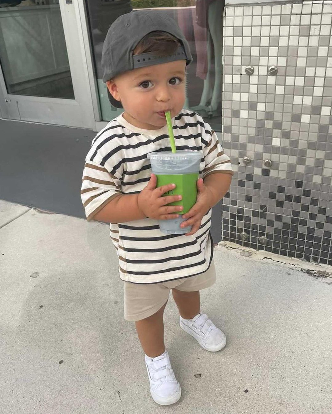 A young guest enjoying a Pure Green smoothie outside the Sunset Harbour store