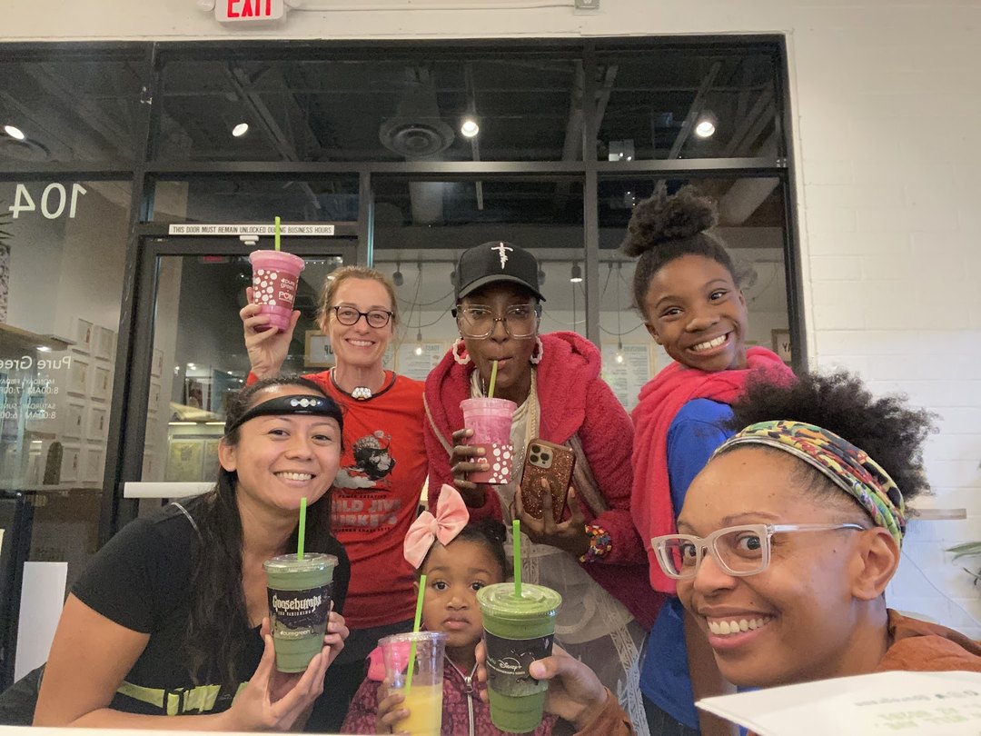 Group of guests holding fresh smoothies at the entrance of Pure Green Tempe
