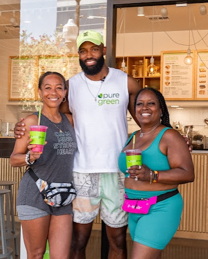 Three guests holding Pure Green smoothies inside the Tempe store