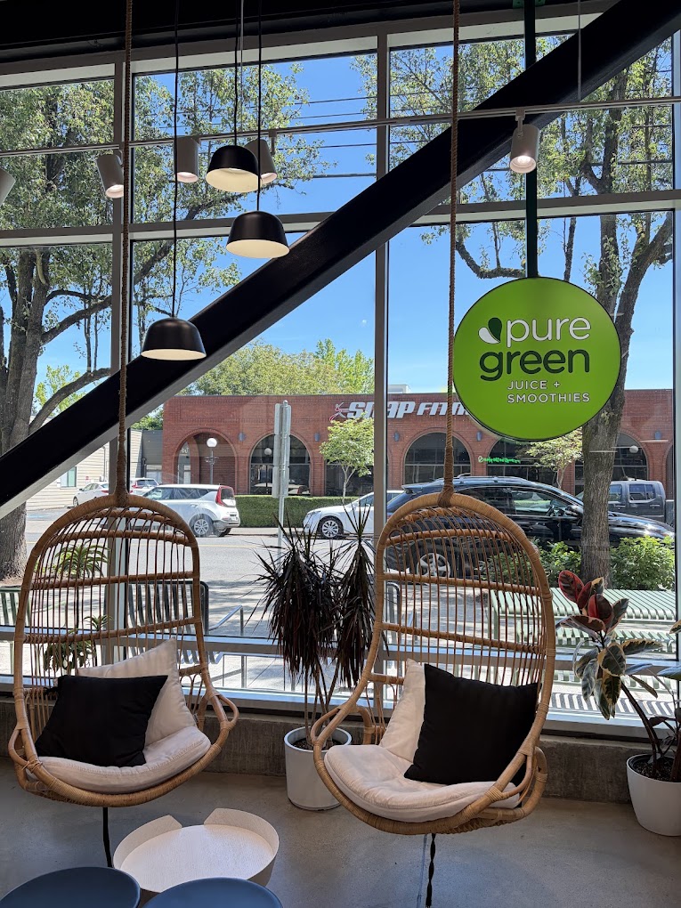 Two hanging rattan chairs at the window inside Pure Green Portland