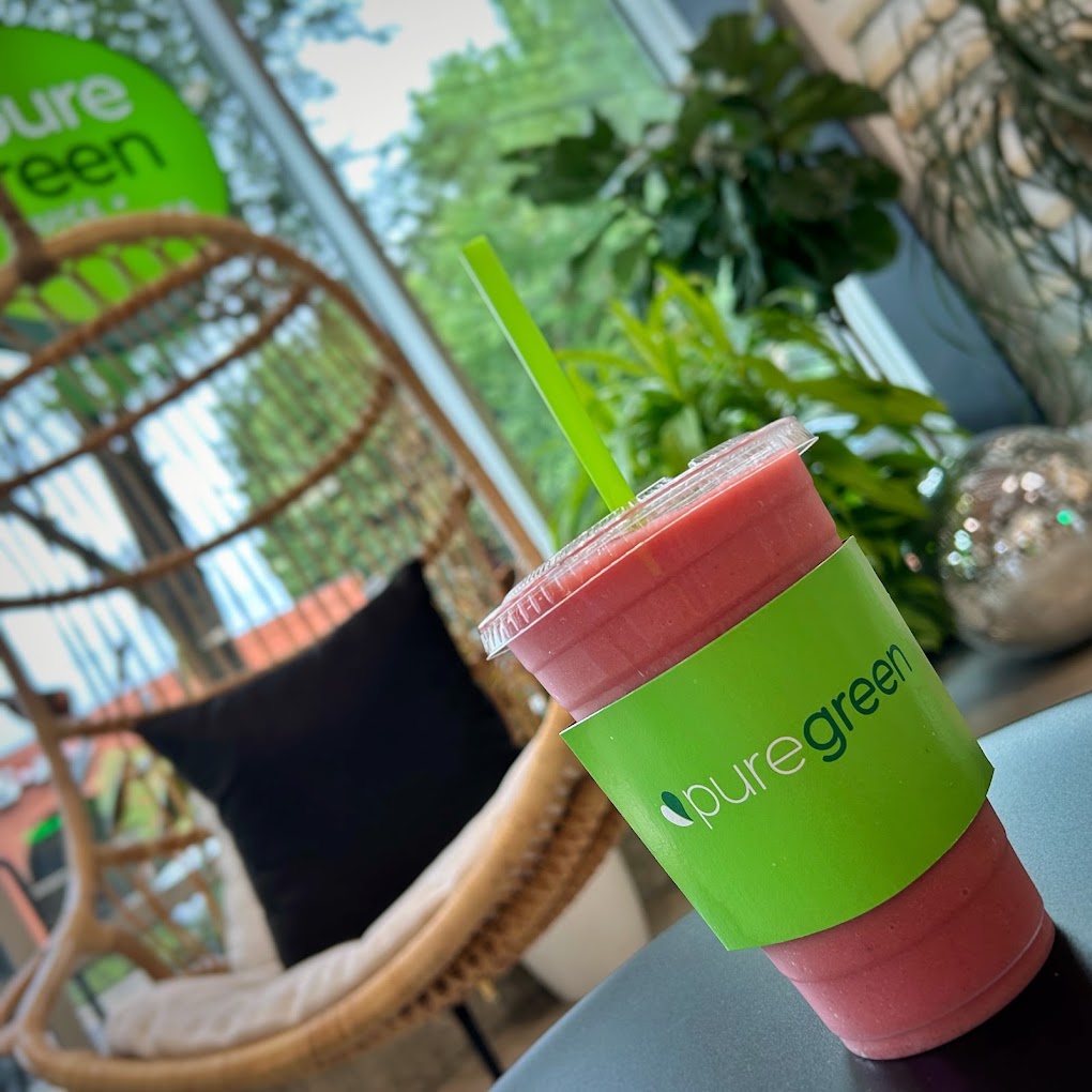 A strawberry smoothie on the table beside a hanging chair at Pure Green Portland