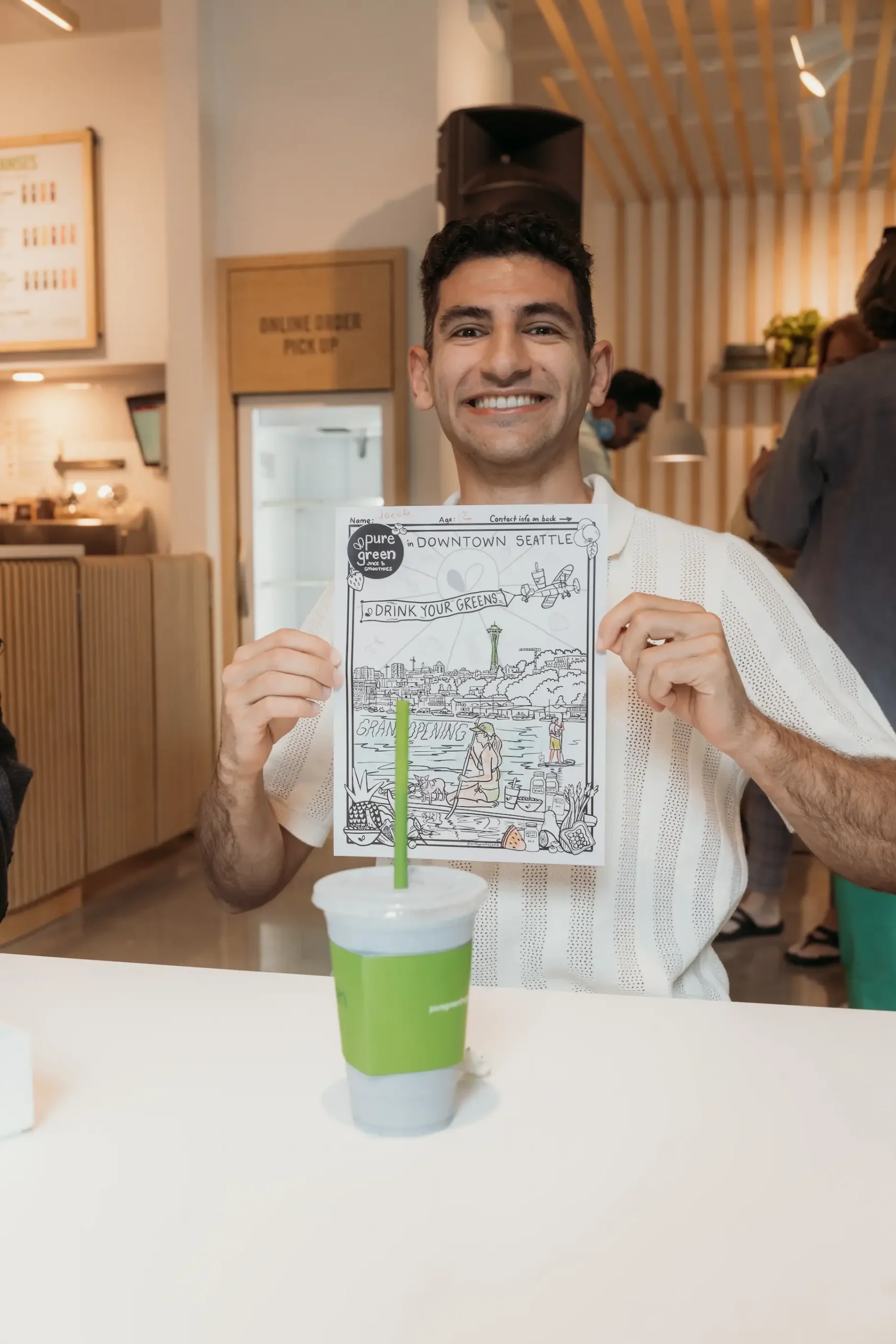 Pure Green visitor holding coloring paper activity